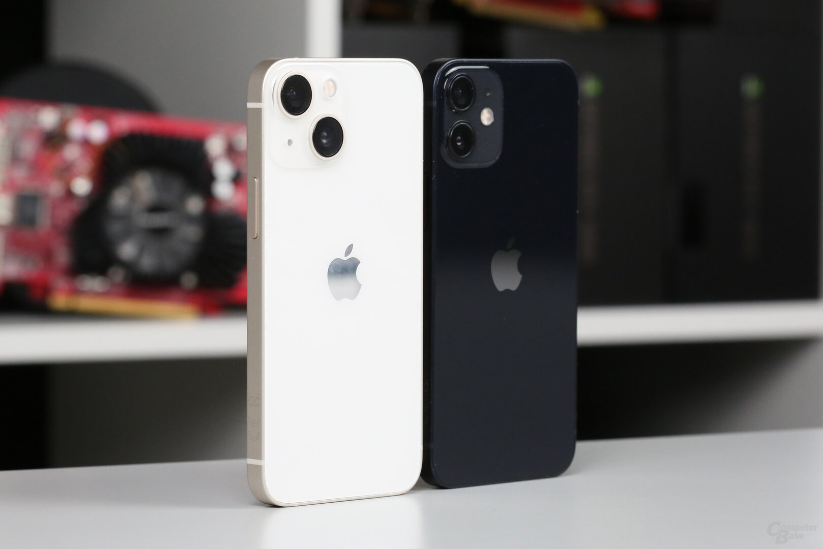 iPhone 13 mini in Polarstern neben schwarzem iPhone 12 mini