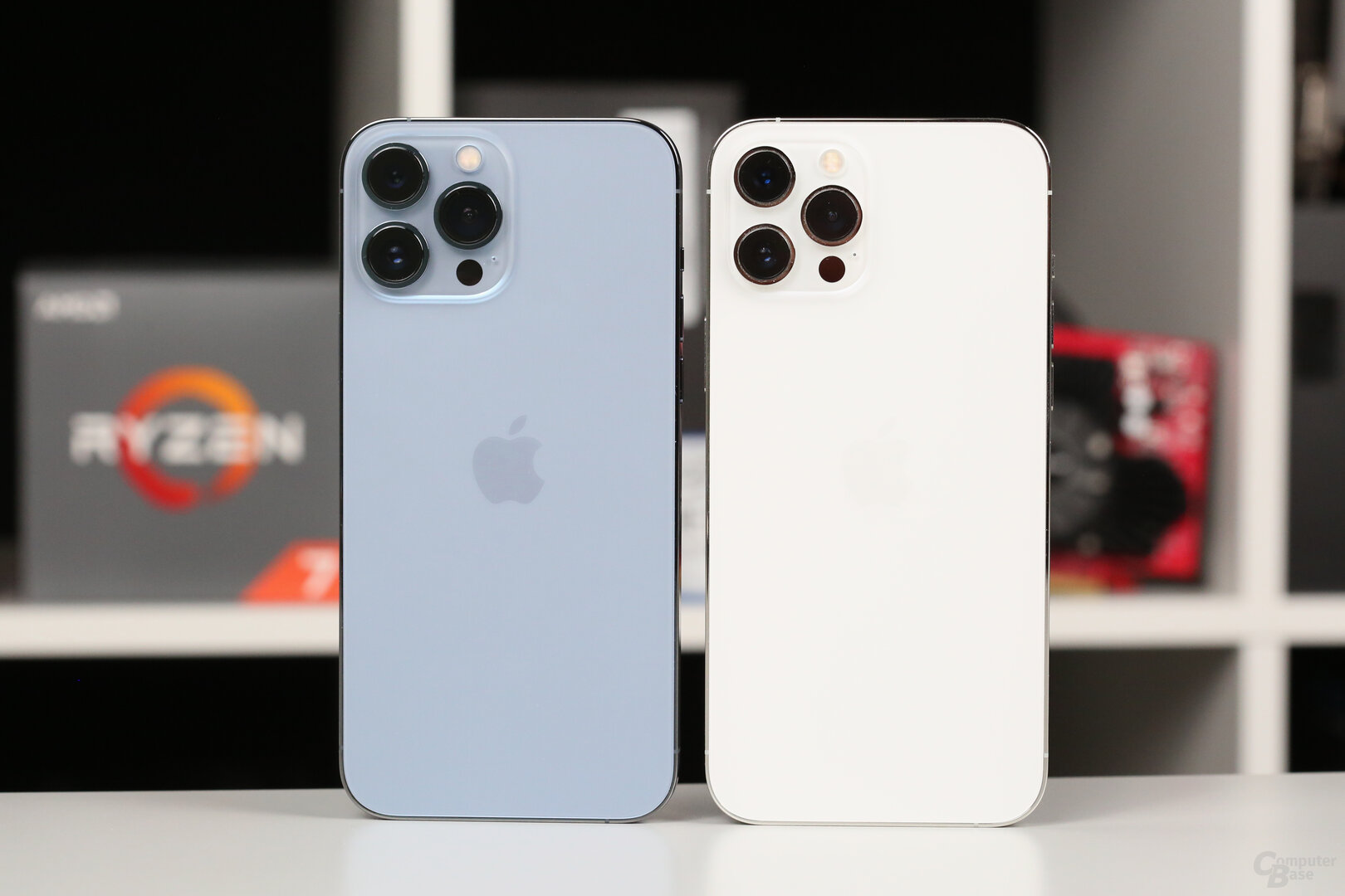 iPhone 13 Pro Max in Sierrablau neben iPhone 12 Pro Max in Weiß