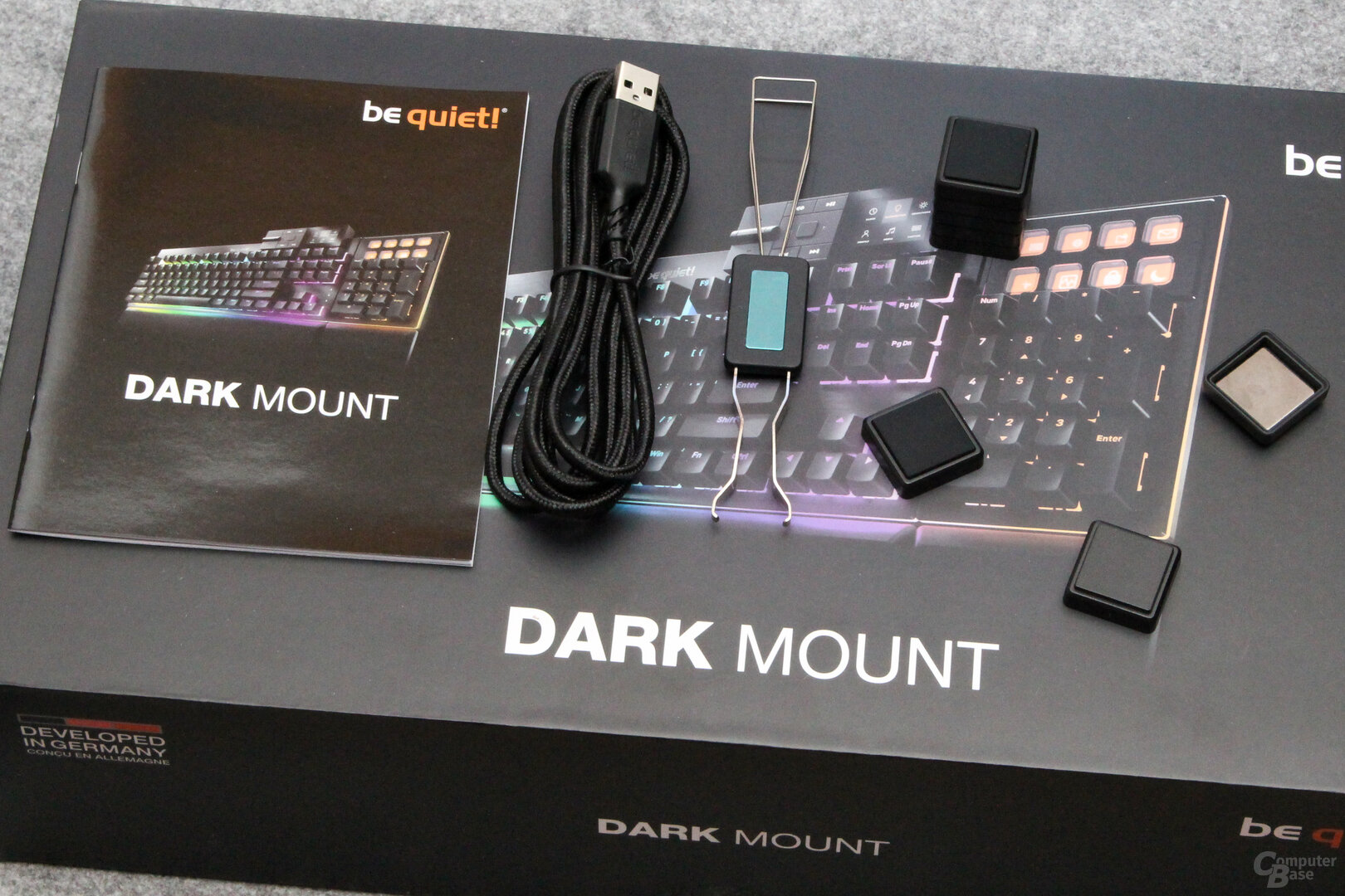 Lieferumfang: Tastenzieher, Kabel, Kurzanleitung, magnetische Stellfüße