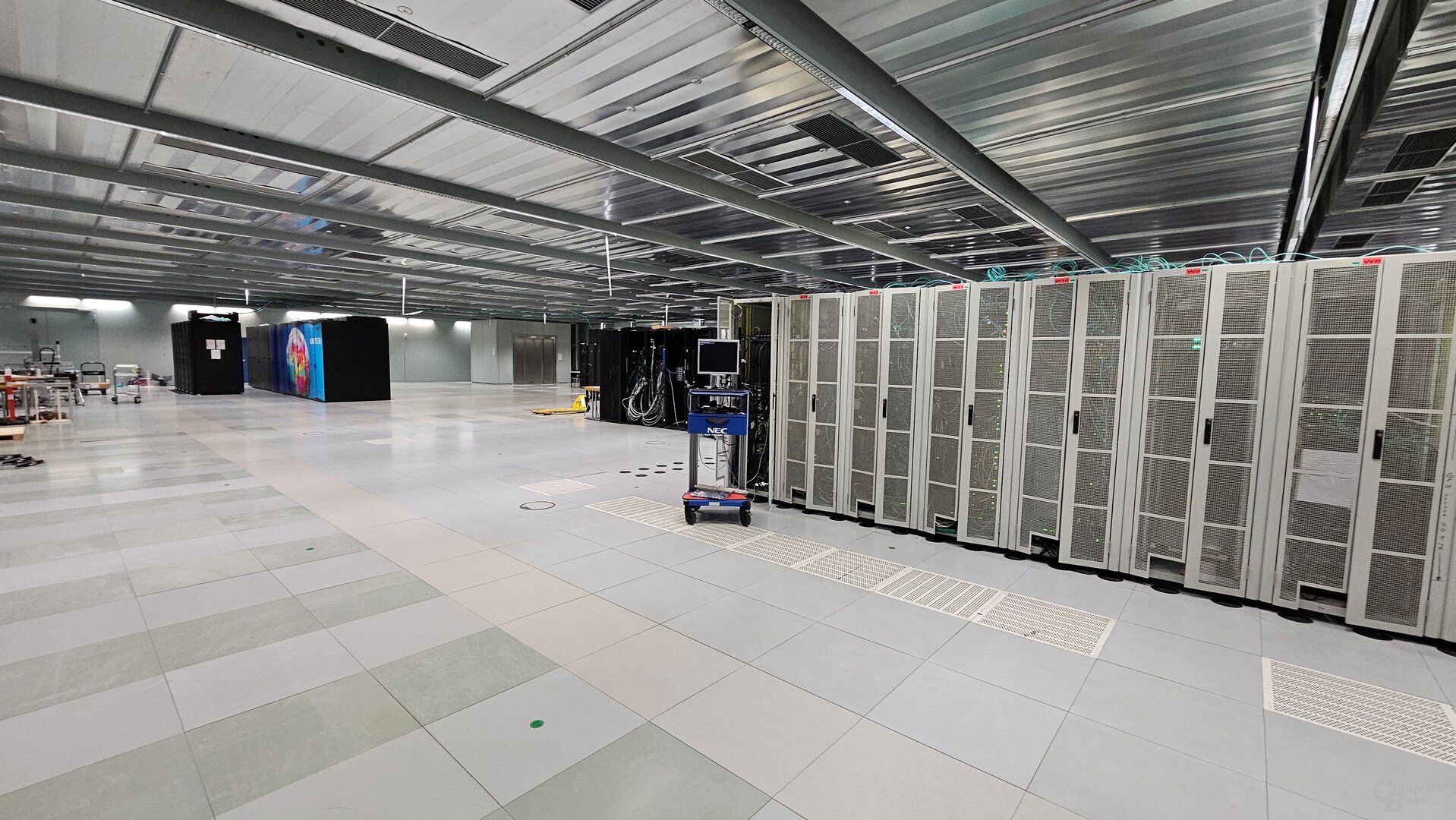 Im großen Rechenzentrum ist der neue Supercomputer fast winzig – hinten links