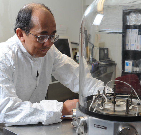 Weng Poo Kang mit einer Vakuumkammer zum Testen der Chips | Quelle: Joe Howell, Vanderbilt University