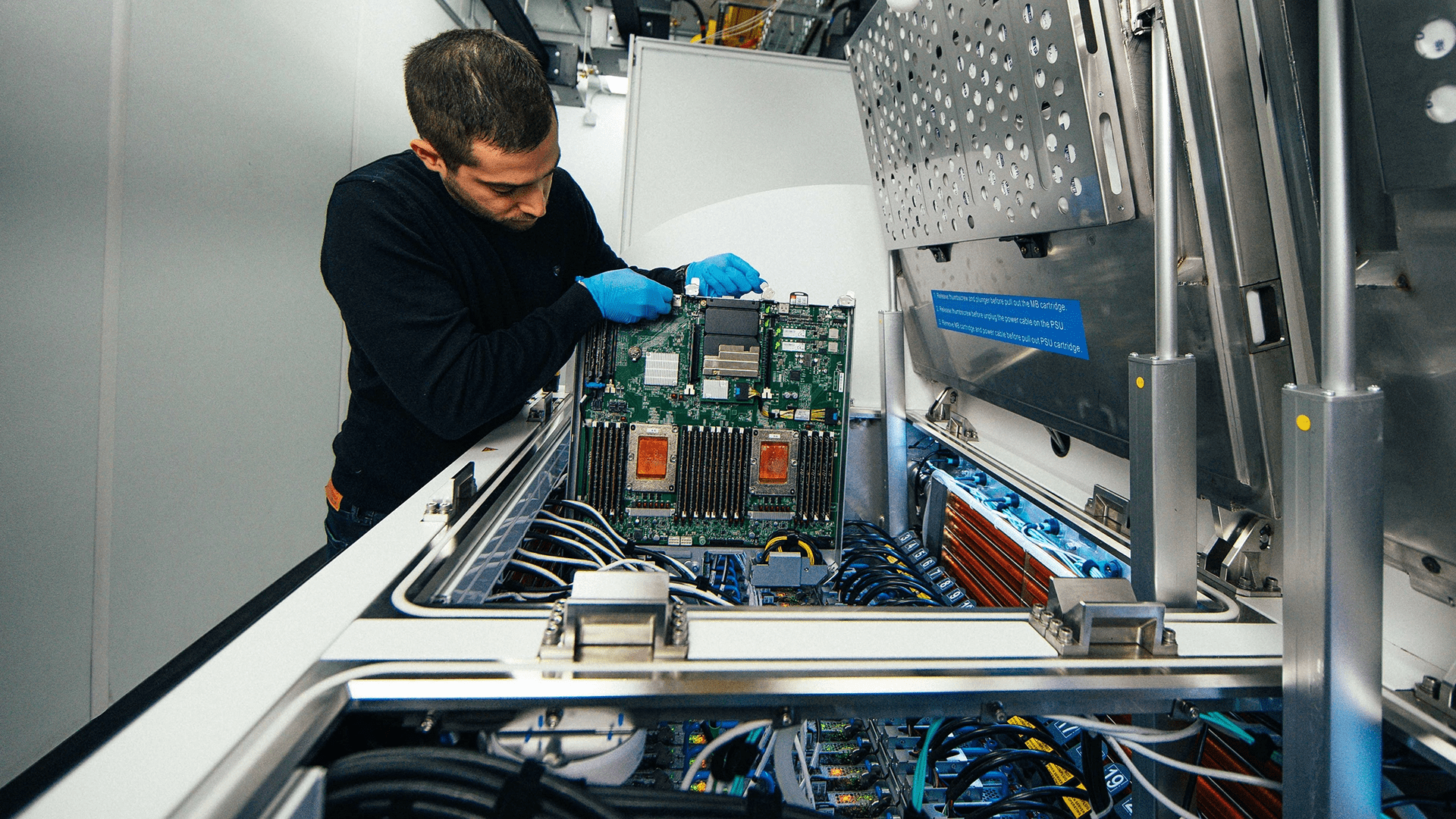 Der Ingenieur entnimmt ein Server-Blade aus einem Zweiphasen-Tauchkühltank